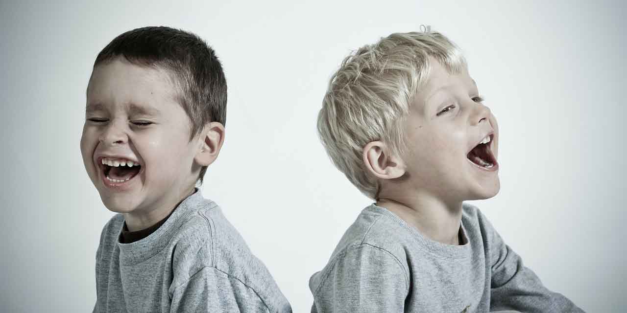 Foto von zwei kleinen Jungen, etwa 3-4 Jahre alt, die herzhaft lachen